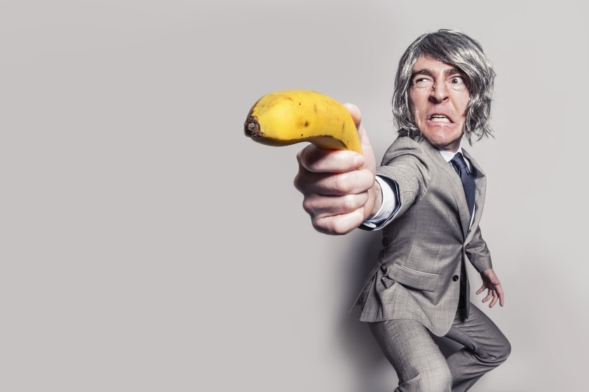 Man using banana as a gun